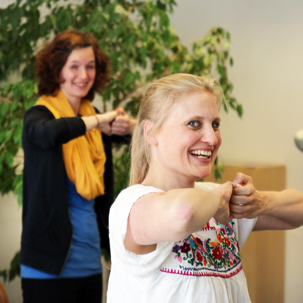 Foto von 2 Mitarbeiterinnen beim Sport im Büro.