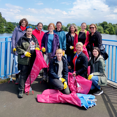 Gruppenfoto der Mitarbeitenden beim Engagement-Tag beim Müllsammeln an der Ruhr.