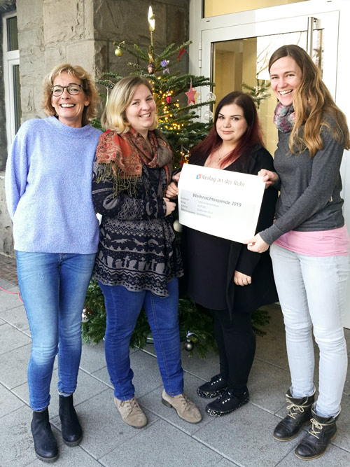 Übergabe der Weihnachtsspende an das SOS Kinderdorf in Form eines großen Schecks.
