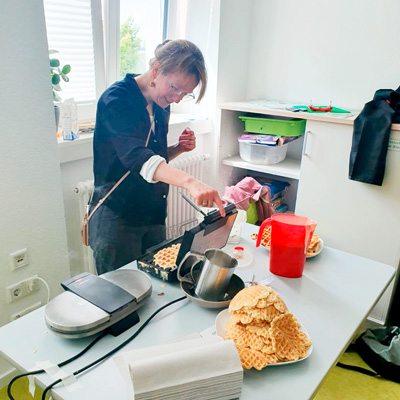 Eine Kollegin backt Waffeln im SOS Kinderdorf.